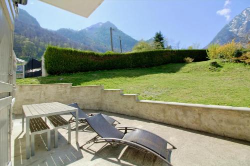 a patio with two chairs and a table and a bench at Sublime Chalet 14 Pers Spa Extrieur in Cauterets