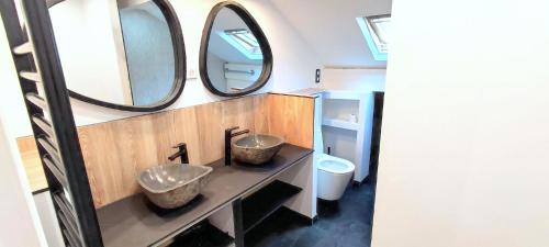 a bathroom with two sinks and two mirrors at Sublime Chalet 14 Pers Spa Extrieur in Cauterets