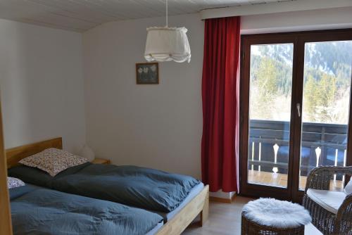 a bedroom with a bed and a large window at Bergführer-Hüsle in Mittelberg