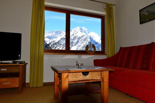 a living room with a view of a snow covered mountain at Bergführer-Hüsle in Mittelberg