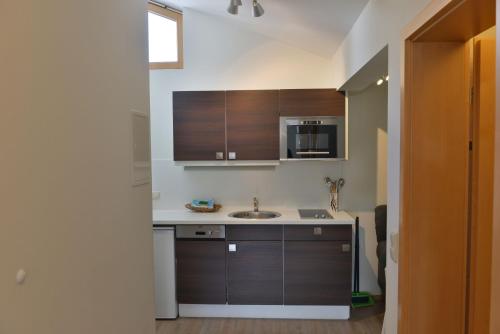 a kitchen with a sink and a microwave at Bergführer-Hüsle in Mittelberg