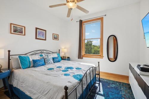 a bedroom with a bed with a ceiling fan and a window at The Starlight Tower Manor, River, Arcades, Observatory, Theater in Fort Atkinson