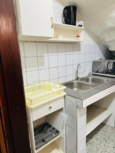 Fajara Heights في سيريكوندا: مطبخ صغير مزود بحوض ومسطح عمل