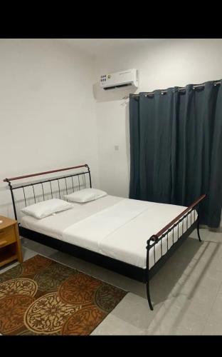 Fajara Heights في سيريكوندا: سرير في غرفة بها ستارة زرقاء