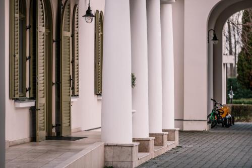 a motorcycle parked next to a building with columns at Hercegasszony Birtok in Mezőtúr