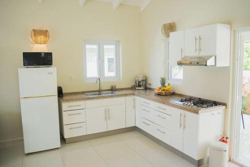 une cuisine avec des armoires blanches et un réfrigérateur blanc dans l'établissement Toscana resort vakantie woning, à Willemstad