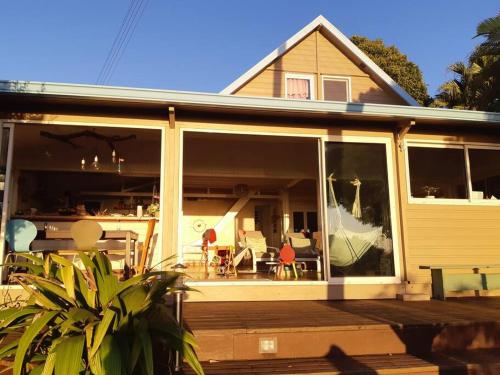 a house with large sliding glass doors on a deck at Grande villa dans l'ouest - belle vue mer - piscine - jacuzzi - 4 chambres - jardin in Saint-Gilles-les Hauts