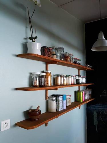 a bunch of shelves on a wall with jars at Grande villa dans l'ouest - belle vue mer - piscine - jacuzzi - 4 chambres - jardin in Saint-Gilles-les Hauts