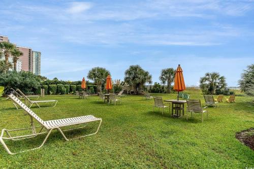 a group of tables and chairs with orange umbrellas at Spectacular Oceanview Condos in Myrtle Beach