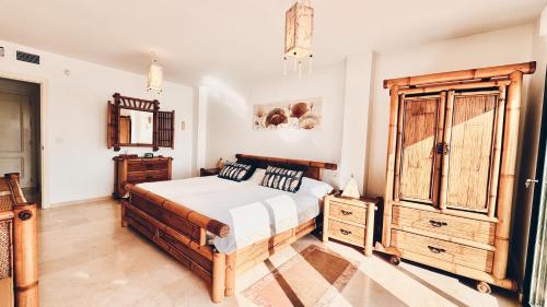 Un dormitorio con una cama y una cómoda de madera. en VillaCarajo La Herradura, en La Herradura