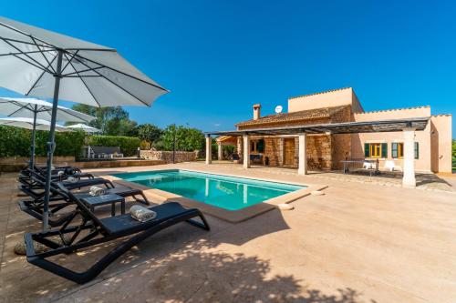 a swimming pool with two lounge chairs and an umbrella at Finca Casa BINITAREF in Sineu