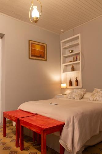 a bedroom with a bed with a red bench on it at Estación Tilcara boutique hotel in Tilcara