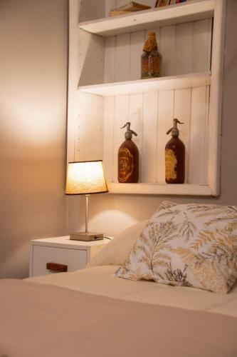 a bedroom with a bed with a lamp and shelves at Estación Tilcara boutique hotel in Tilcara