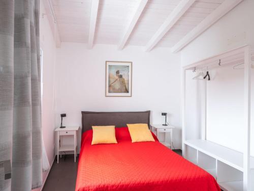 a bedroom with a red bed with two yellow pillows at Villa Timpi Rossi Total Relax in Alcamo