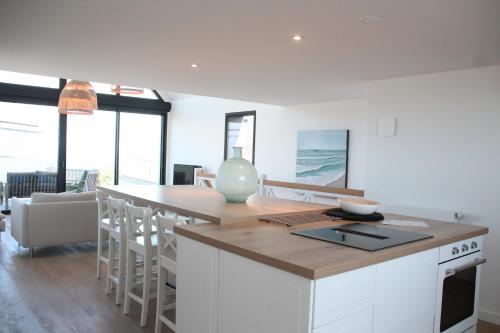 - une cuisine avec îlot central et comptoir dans l'établissement Ty Dag - Petite Terre vue mer, spa, plage à 300m, à Roscoff