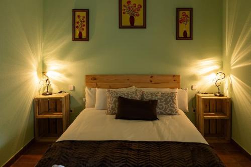 a bedroom with a large bed with two night stands at Casa los toriles in Ortigosa del Monte