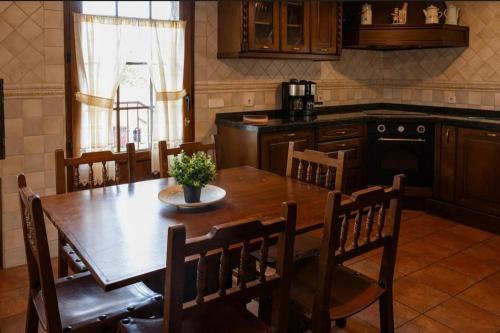 a kitchen with a wooden table with chairs and a dining room at Casa los toriles in Ortigosa del Monte