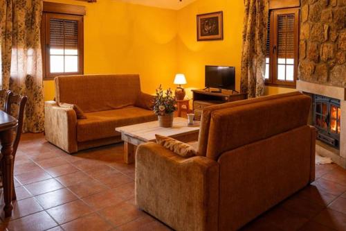 a living room with two couches and a fireplace at Casa los toriles in Ortigosa del Monte