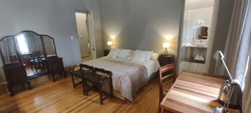 a bedroom with a bed and a table and a mirror at Estación Tilcara boutique hotel in Tilcara