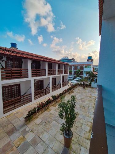 a balcony of a building with a courtyard with plants at Estação do Sol Praia Hotel in Porto De Galinhas