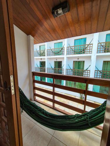 a hammock in a room with a building at Estação do Sol Praia Hotel in Porto De Galinhas