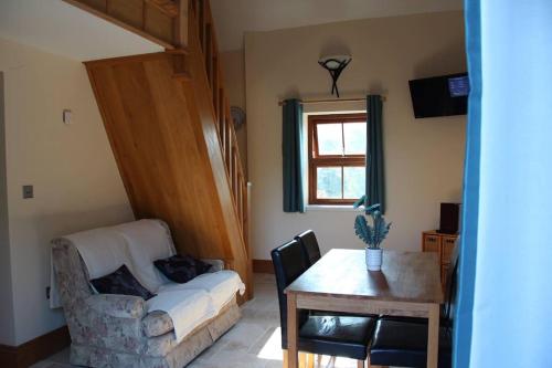 salon z kanapą i stołem w obiekcie Broadway Farm Holiday Barn with hot tub w mieście Swansea
