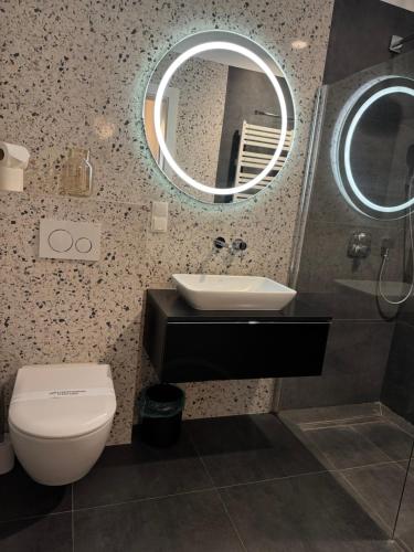a bathroom with a toilet and a sink and a mirror at Modern Vero Apartments Portova in Gdynia