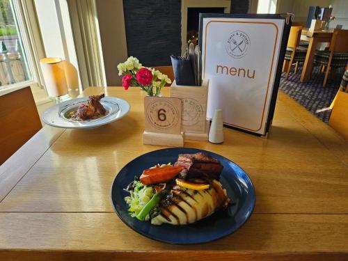 a table with two plates of food on it at Old Orleton Inn in Wellington