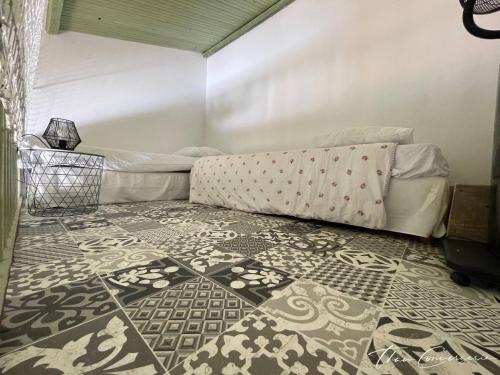 a bedroom with a bed and a patterned floor at Villa Familiale avec Piscine proche de Sète et de Montpellier in Poussan