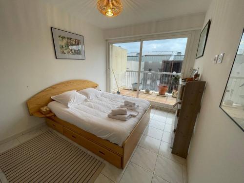 une chambre avec un lit et une grande fenêtre dans l'établissement Sète - bel appartement 4 étoiles avec terrasse vue Saint Clair - plein centre - garage, à Sète
