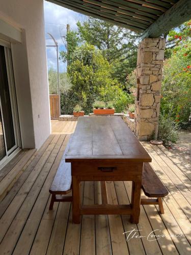 a wooden table sitting on a wooden deck at Villa Familiale avec Piscine proche de Sète et de Montpellier in Poussan