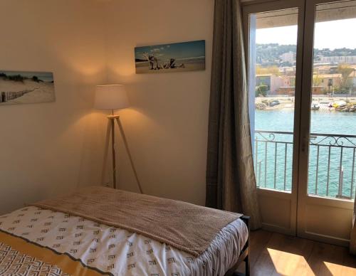 une chambre avec un lit et une fenêtre avec vue dans l'établissement Petit nid coquet à la Pointe Courte, à Sète