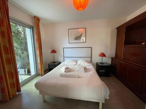 une chambre avec un lit blanc et une grande fenêtre dans l'établissement Sète, Villa 4 étoiles avec piscine à deux pas de la plage !, à Sète