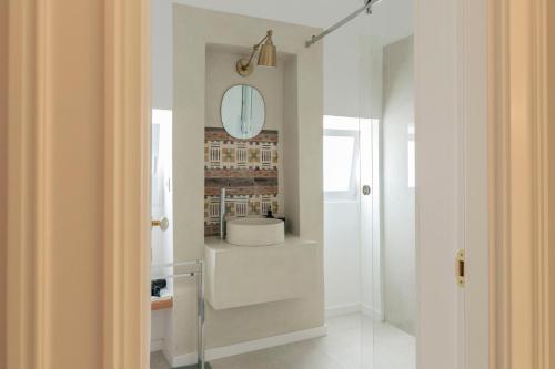 a bathroom with white walls and a mirror on the wall at Palazzo AD 1892 - SUITES & SPA in Ostuni