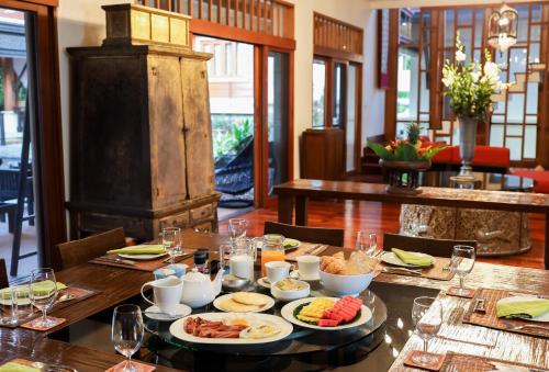 een tafel met daarop borden met eten bij Villa Salika in Rawai Beach