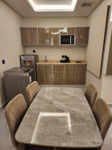 a kitchen with a large marble table and chairs at شقق أمواج للشقق المخدومة in Al Khobar