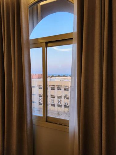 a window with a view of a building at شقق أمواج للشقق المخدومة in Al Khobar