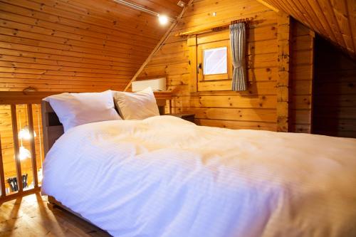Postel nebo postele na pokoji v ubytování Three Peaks Log スリーピークス ログ