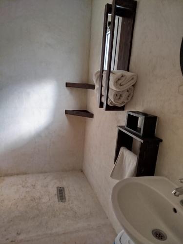 a bathroom with a sink and a toilet and a mirror at Surfiscamp Dakhla in Dakhla