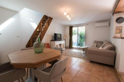 un salon avec une table et un canapé dans l'établissement Fé Di Biou - Jardin Parking Clim, à Arles