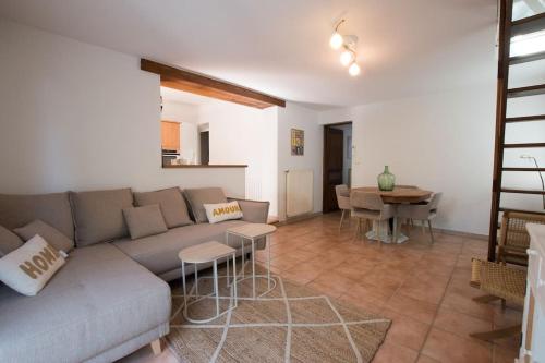 a living room with a couch and a table at Fé Di Biou - Jardin Parking Clim in Arles