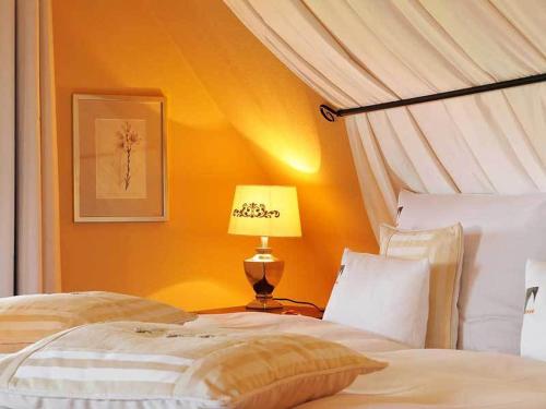 a bedroom with two beds and a lamp on a table at Hotel Herrnschloesschen in Rothenburg ob der Tauber