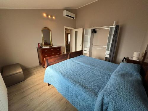 a bedroom with a blue bed and a dresser and a mirror at Appartamento Le lame in Corte Franca