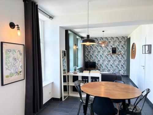 une salle à manger avec une table et une cuisine dans l'établissement Bel Appartement Jusqu'a 4 voyageurs, à Lille