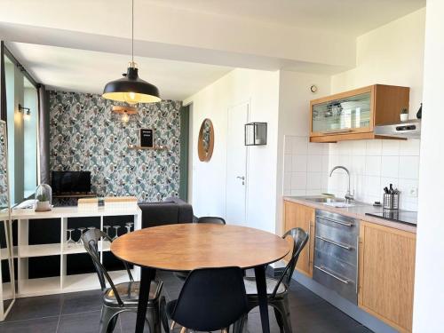 une cuisine avec une table et des chaises dans une pièce dans l'établissement Bel Appartement Jusqu'a 4 voyageurs, à Lille