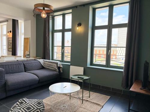 un salon avec un canapé et une table dans l'établissement Bel Appartement Jusqu'a 4 voyageurs, à Lille