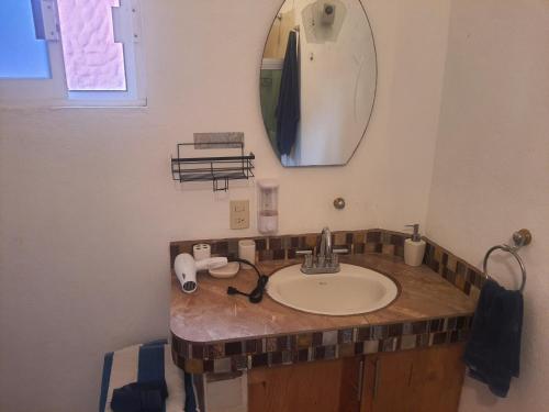 a bathroom with a sink and a mirror at Bungalow Maya Luna in Playa Estacahuite