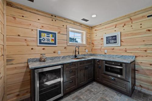 a kitchen with wooden walls and a sink and a stove at Marianne’s in Avon