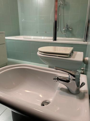 a bathroom with a sink and a toilet and a tub at Appartamento Marisa in San Vendemiano