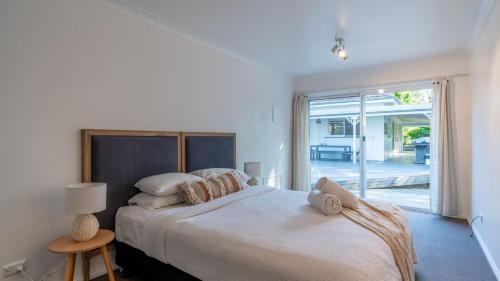 a bedroom with a large bed and a sliding glass door at Bali Huts Escape in Nowra